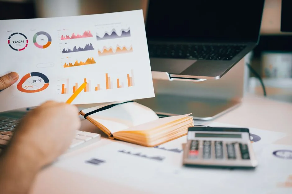 A bird's-eye view of charts and a smartphone in an office, highlighting data analytics.